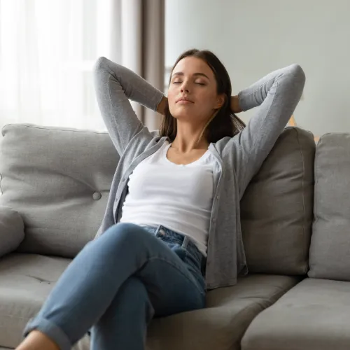 A person sitting calmly in a comfortable home environment, reflecting emotional balance, reflection, and everyday mental well-being.