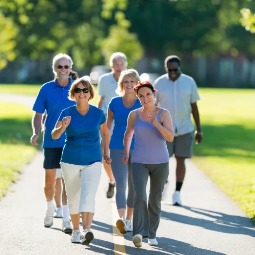 Mature adults walking together outdoors as part of an active everyday lifestyle.
