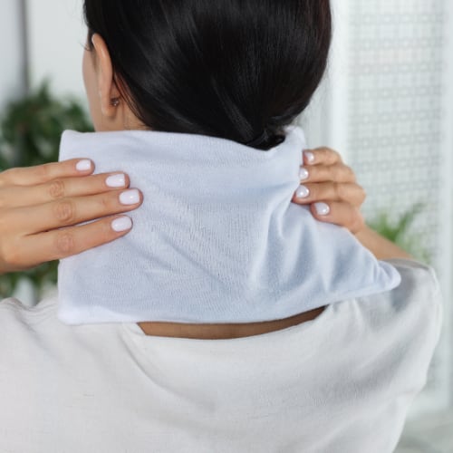 warm comprress applied to back of neck as heat therapy