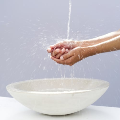 woman washing her hands over a bowl