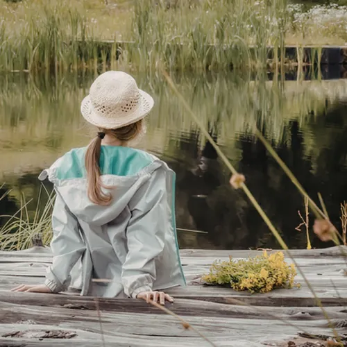 A person sitting quietly in a calm setting, reflecting on daily experiences and maintaining emotional balance and perspective.