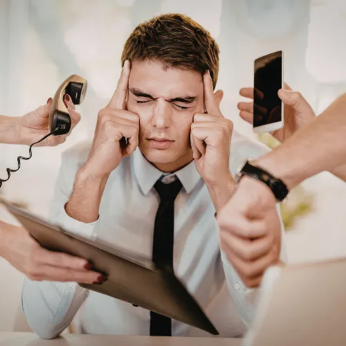 A person surrounded by screens and notifications in a busy modern environment that reflects ongoing overstimulation.