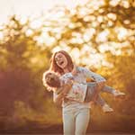 Woman and daughter playing together outside