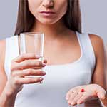 Unhappy Woman holding pill with water