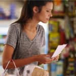 Woman Shopping with List in Grocery Store for Dairy Free Foods