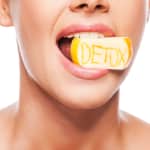 woman with yellow apple in mouth that says detox