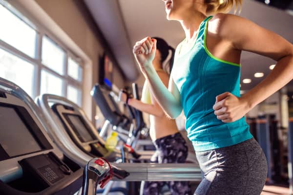two women exercising on treadmills