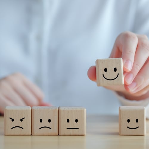 wooden blocks with facial expressions depicting a range of relationships from healthy to unhealthy